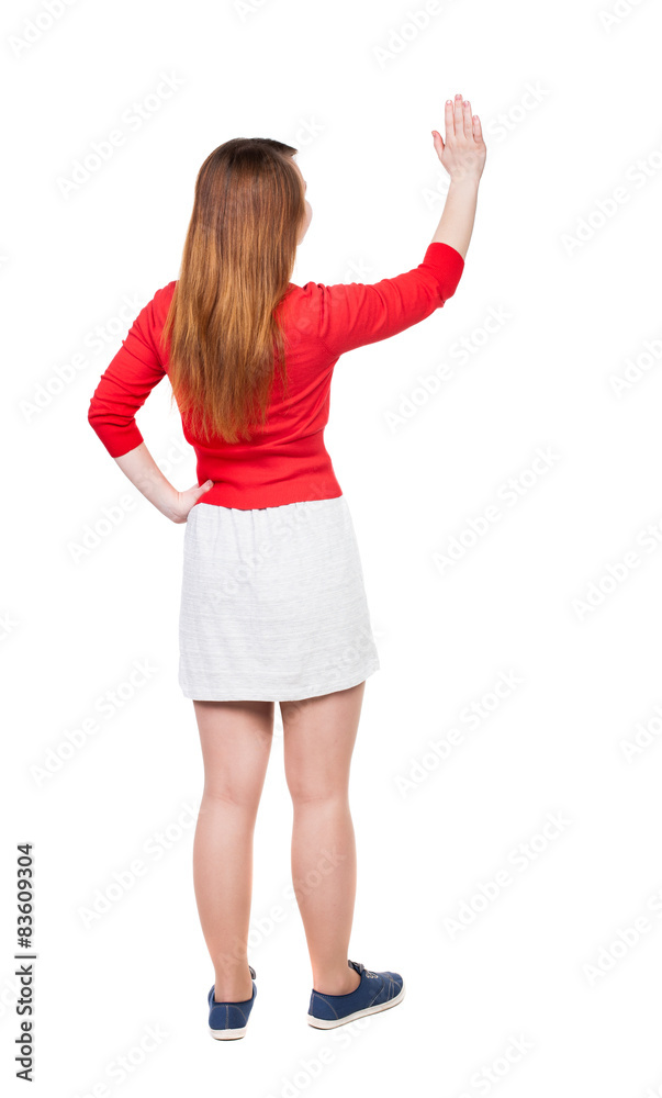 back view of woman. Young woman presses down on something. back view of woman. Young woman presses down on something.