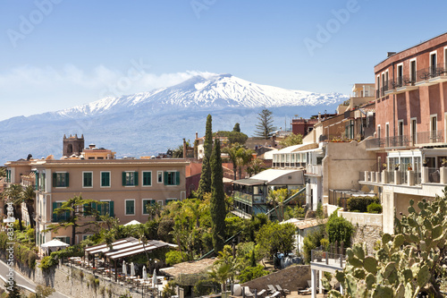 Sicilian town Taormina with white peak of smoking volcano Etna © Yols