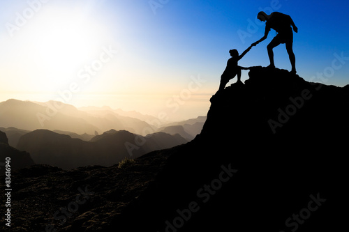 Teamwork couple hiking helping hand