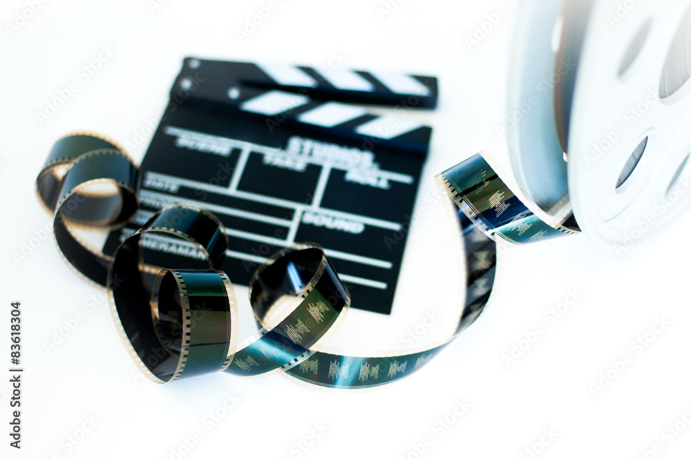 Movie clapper and vintage 35 mm film cinema reel on white Stock Photo