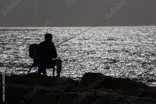 The silhouette of fisher on the seaside in Tel Aviv