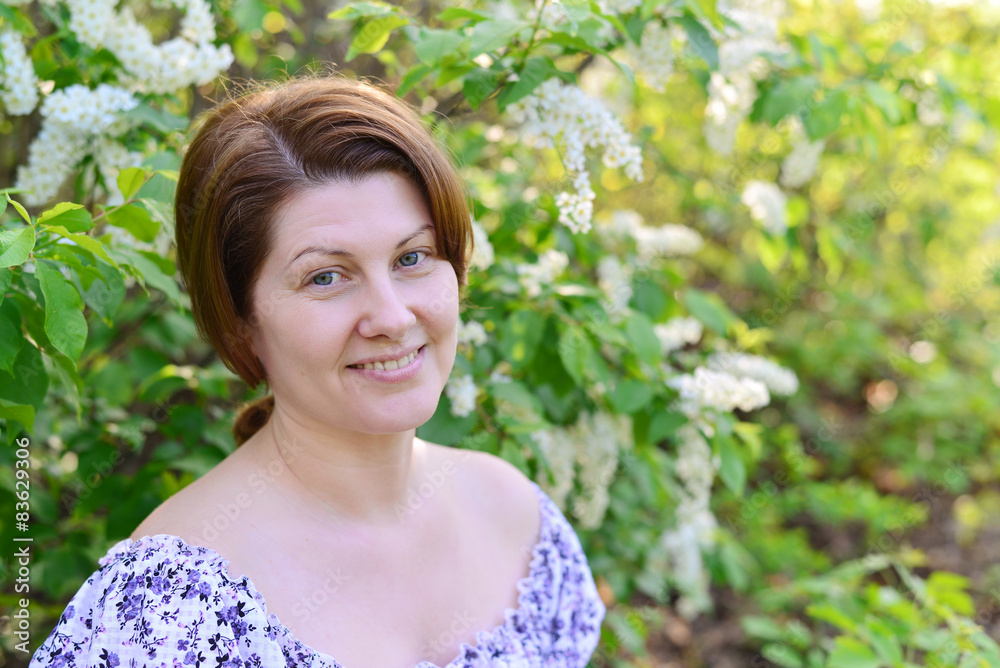 adult woman near blossoming bird cherry in the park adult woman near blossoming bird cherry in the park