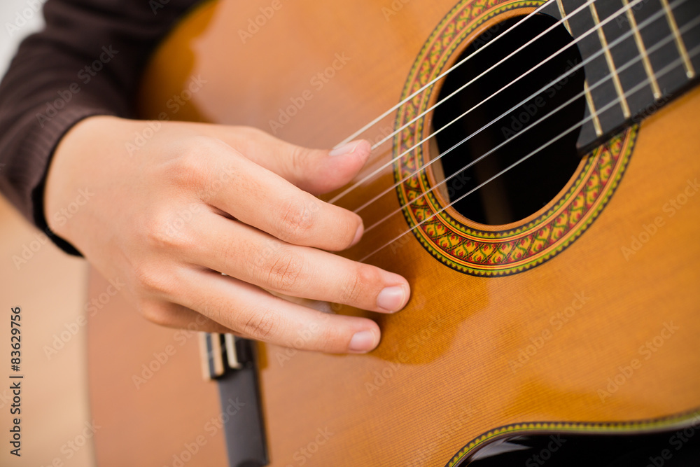 Fototapeta premium Practicing in playing guitar. Handsome young men playing guitar