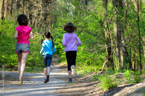 Family sport, mother and kids jogging, running in forest 