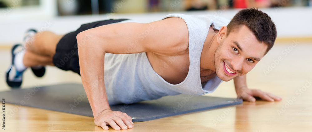 smiling man doing push-ups in the gym smiling man doing push-ups in the gym