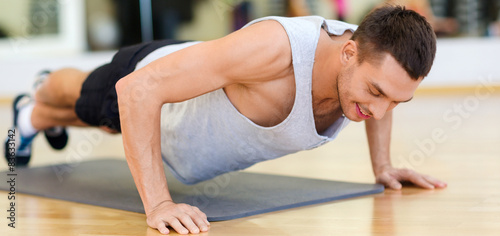 smiling man doing push-ups in the gym