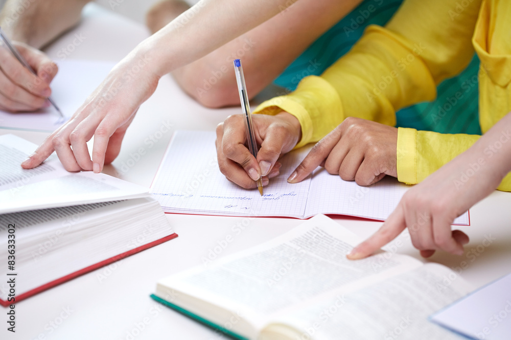 close up of students hands writing to notebooks close up of students hands writing to notebooks