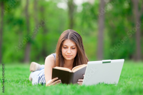 girl with laptop computer and book