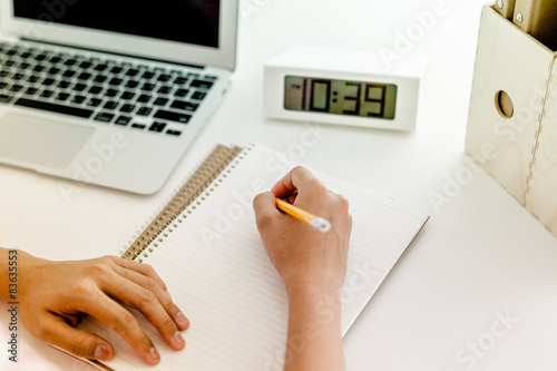 woman using her laptop with clock