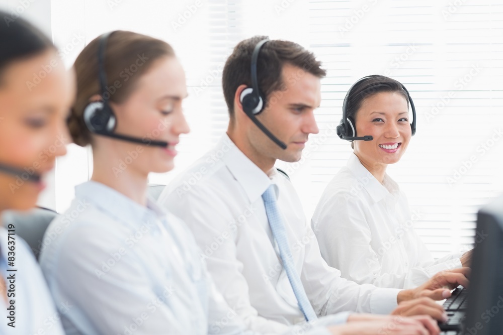 Business people with headsets using computers Business people with headsets using computers