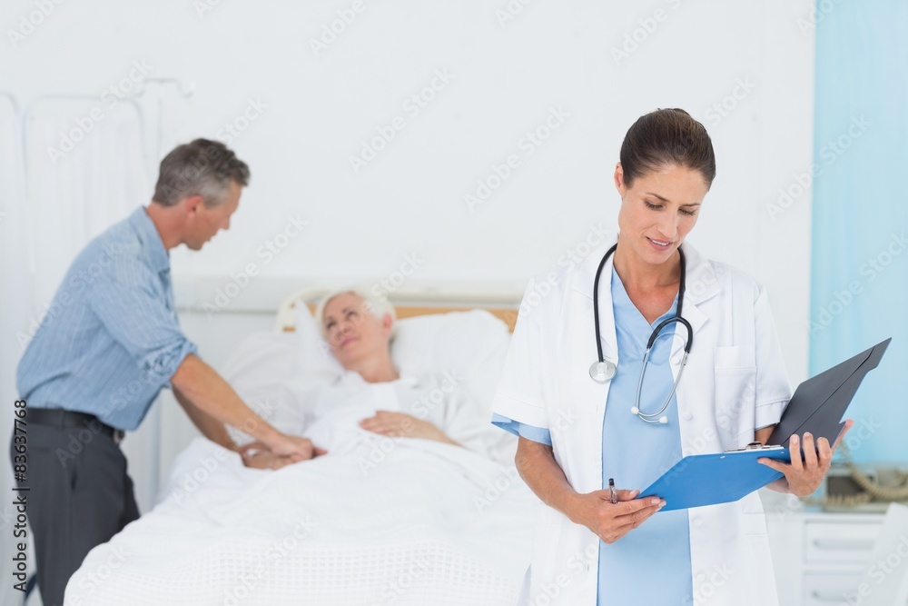 Doctor explaining report to female patient and husband Doctor explaining report to female patient and husband