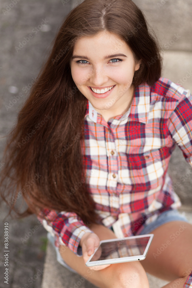 Obraz premium Face portrait of young woman using a tablet pc