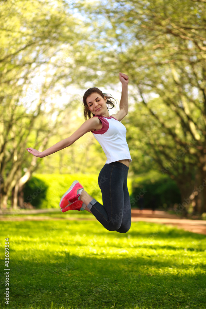 Happy sportive girl jumping in green summer park Happy sportive girl jumping in green summer park