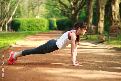 Sportive girl working out doing push ups press exercise