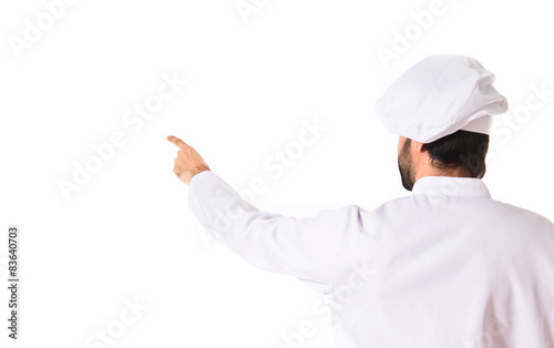 Chef pointing back over white background