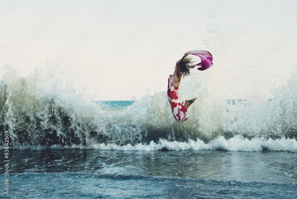 Naklejka premium Woman jumping on the beach 