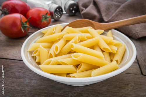 Raw penne pasta in bowl