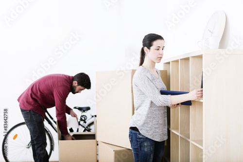 Fotografie beautiful young couple unpacking and flying in new home