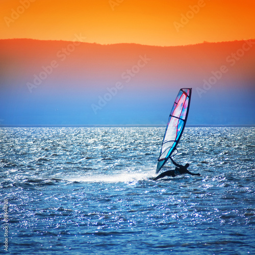 Windsurfer silhouette against a sunset background