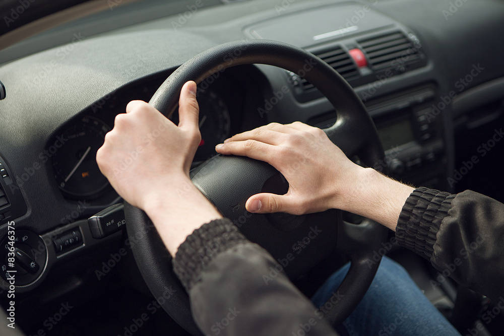 Close-up of  male hand on steering wheel in car