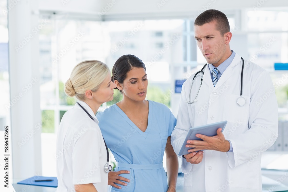 Doctors looking together at tablet Doctors looking together at tablet