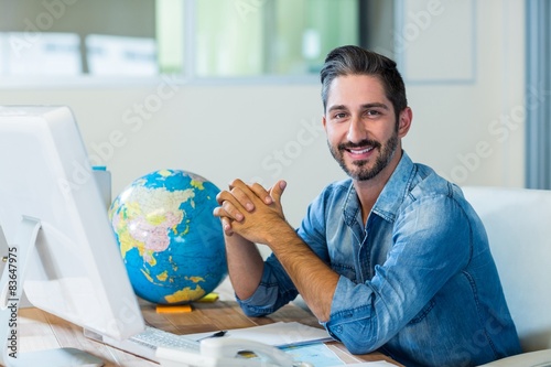 Smiling businessman sitting at his desk photo