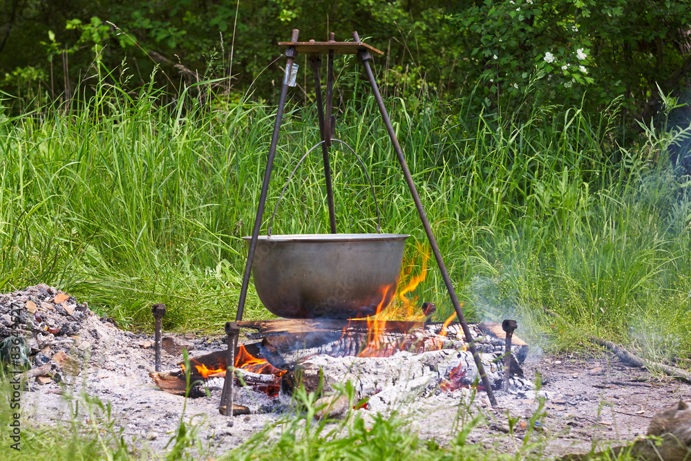 Cast Iron Cauldron Hanging Over Campfire on Tripod Outdoor Cooking Cast Iron Cauldron Hanging Over Campfire on Tripod Outdoor Cooking