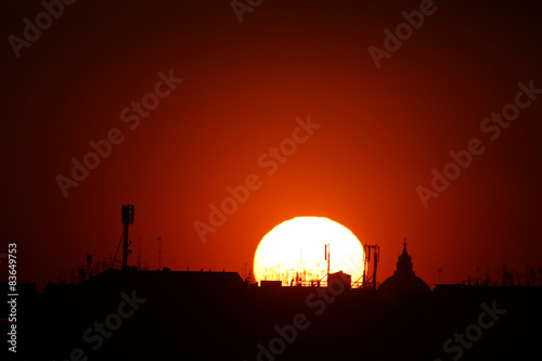 sole al tramonto a roma con antenne