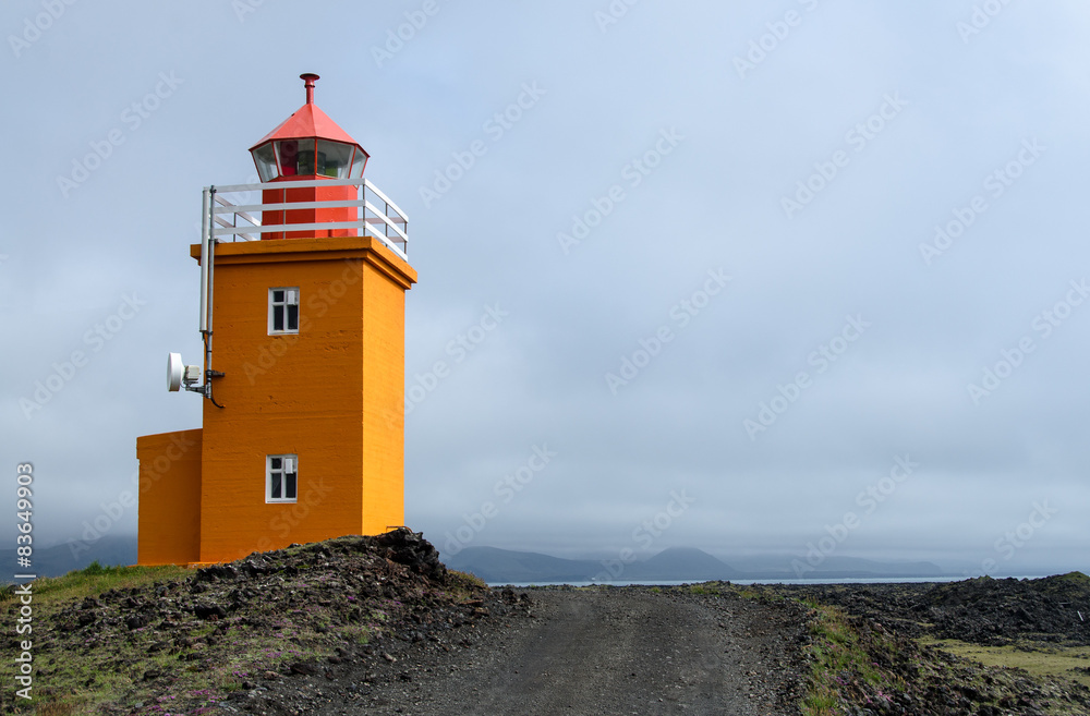 Oranger Leuchtturm an der Küste von Island