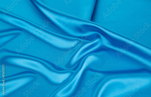 Folds of blue silk cloth texture.
