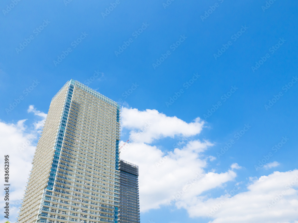 building and cranes under construction against blue sky building and cranes under construction against blue sky