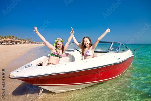 Two girls are sitting in a boat on the sea