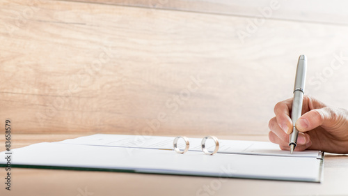 Closeup of female hand signing divorce papers