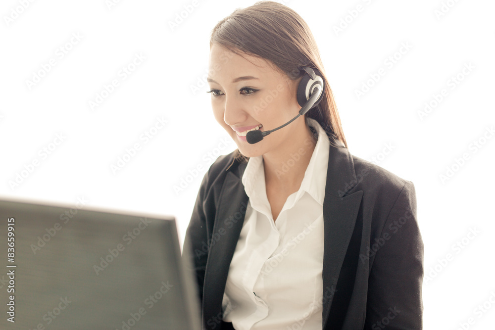 businesswoman talking on the phone while working on her computer businesswoman talking on the phone while working on her computer