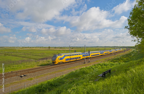 Train riding through a sunny landscape in spring