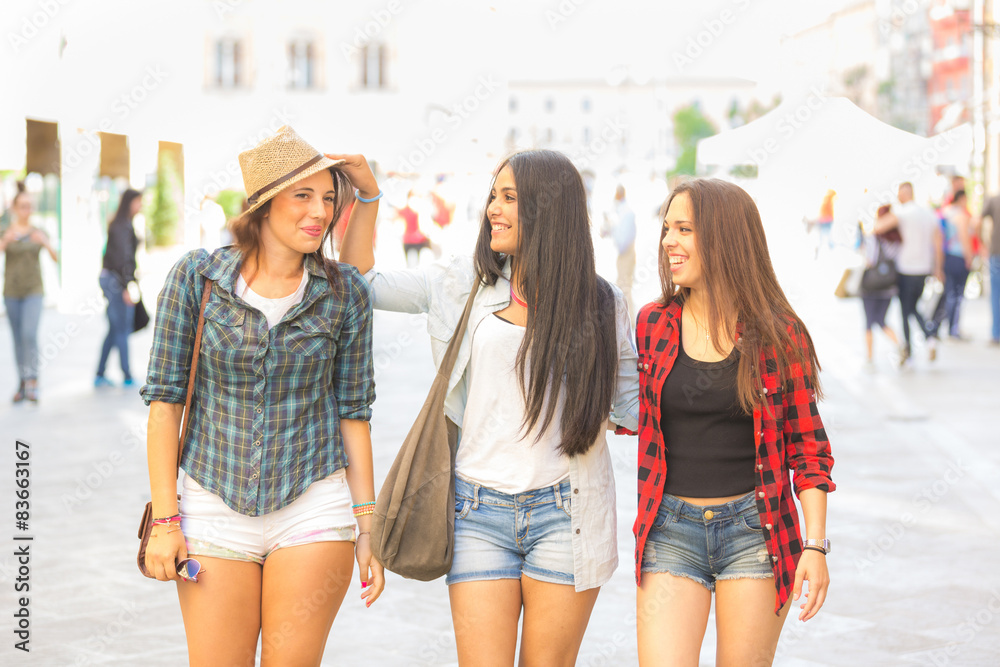Three happy women walking in the city