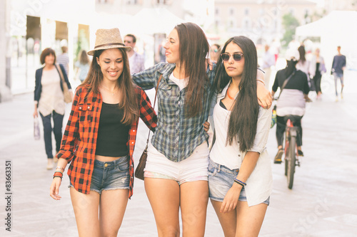 Three happy women walking in the city