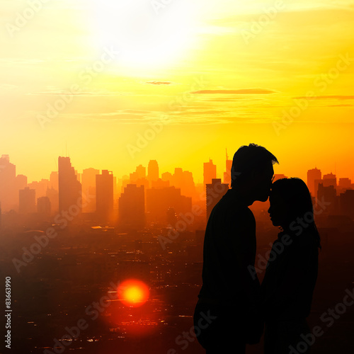 Romantic couple kissing in the city when sunrise.