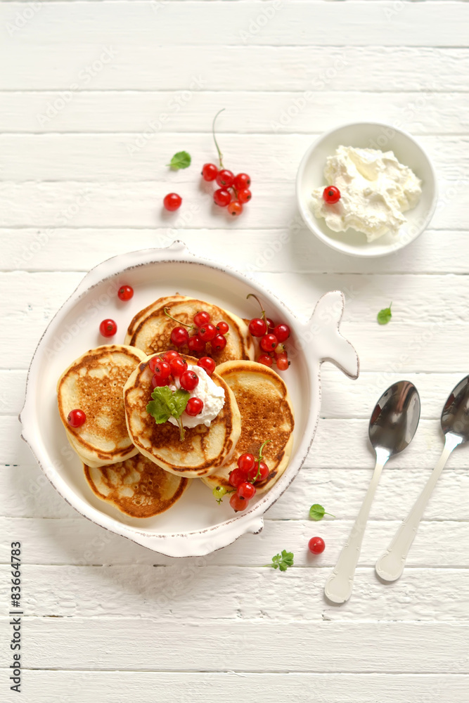 pancakes with cream and red currants in a vintage plate pancakes with cream and red currants in a vintage plate