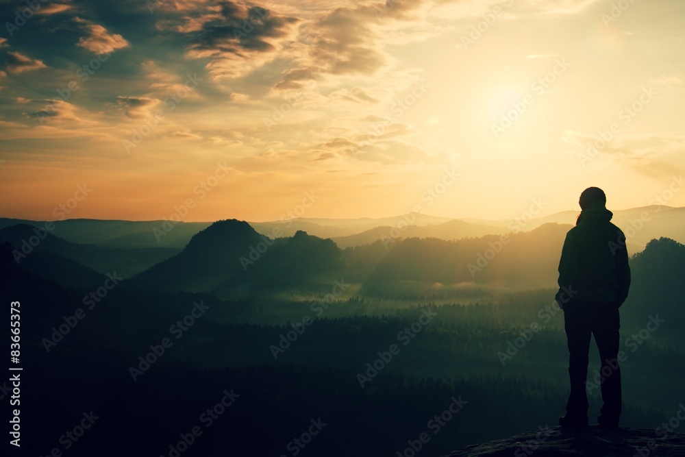 Girl on sharp rock empires above misty valley of the world