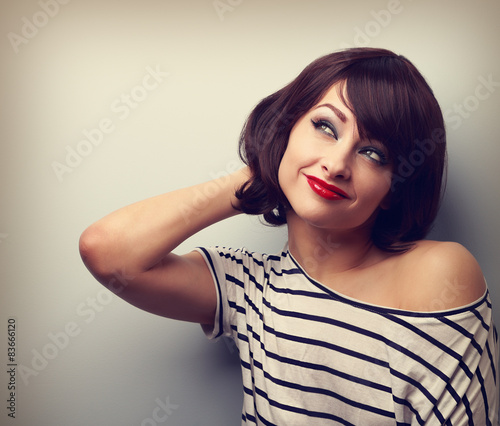 Beautiful smiling thinking young woman looking up. Vintage portr