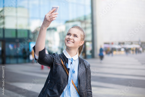 Joyful woman taking selfie in city center