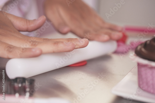 Young woman chef cooking cake in kitchen