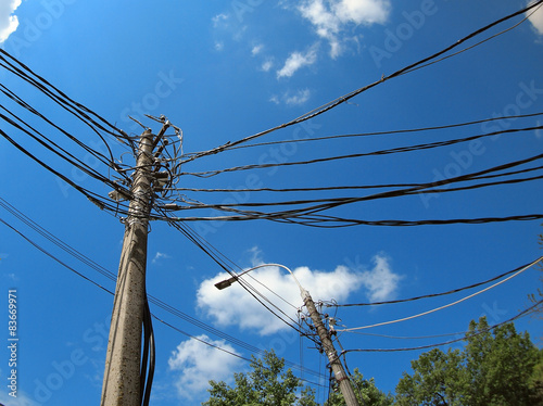 Poles with a lot of wires and electric lamps lighting