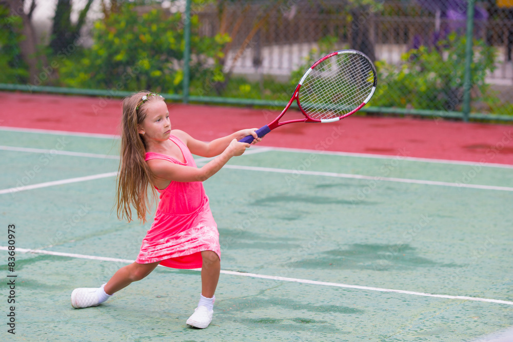 Little girl playing tennis on the court