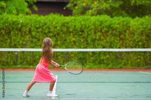 Little girl playing tennis on the court © travnikovstudio