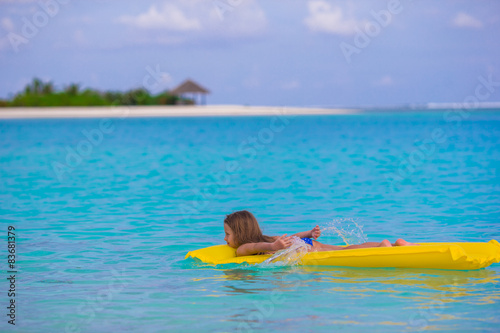 Adorable little girl on air inflatable mattress in the sea © travnikovstudio
