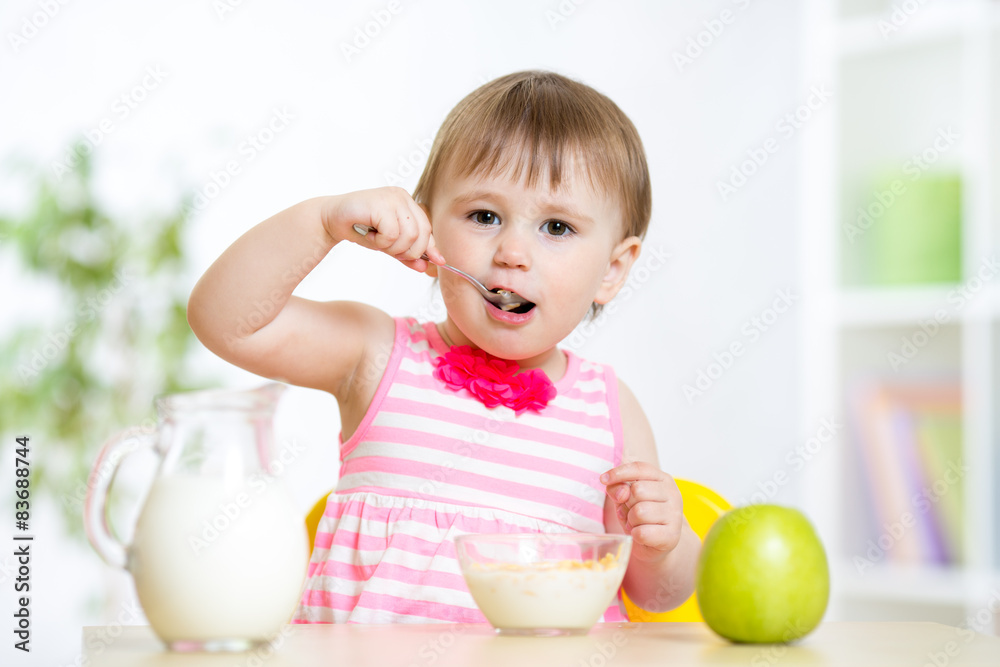 happy kid girl eating food itself with spoon happy kid girl eating food itself with spoon