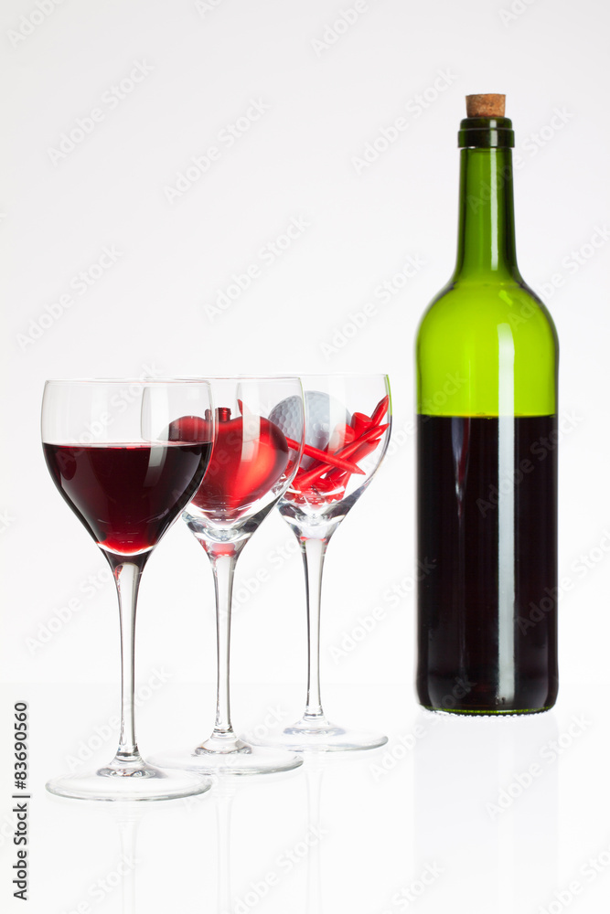 Wine glasses with red wine, heart and golf ball