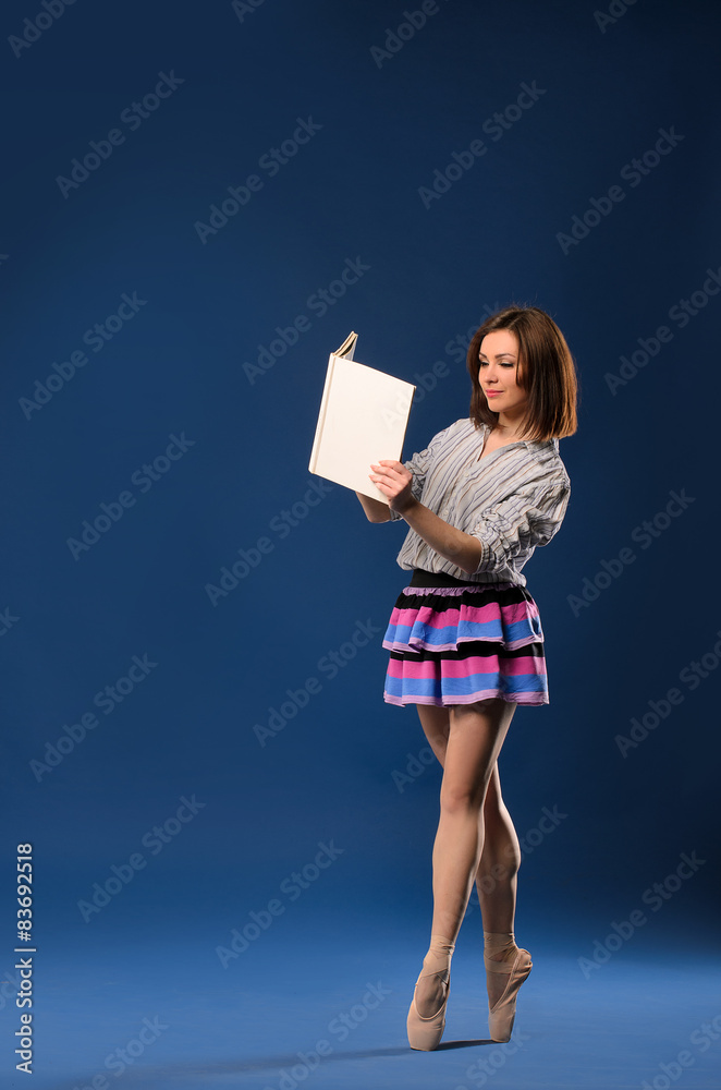 Fototapeta premium female dancer on tiptoe reading book